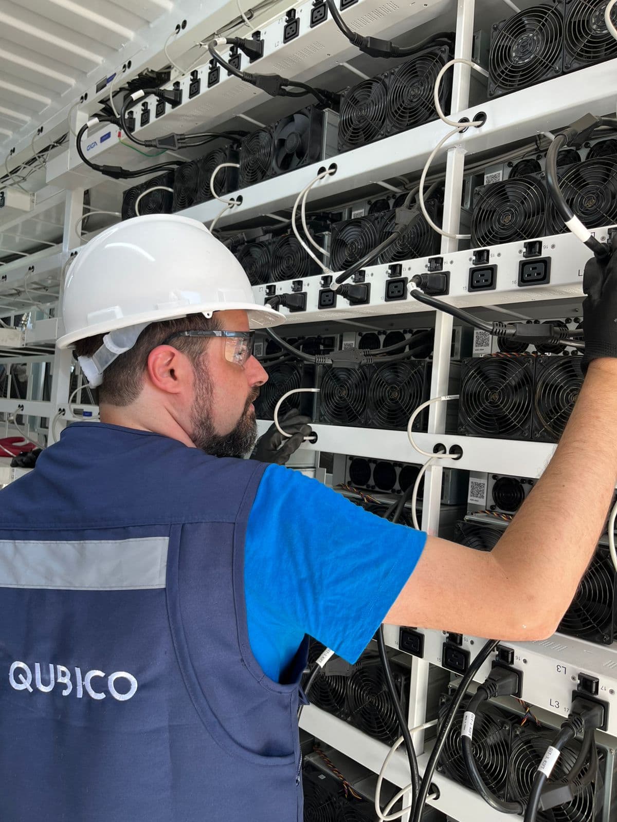 Qubico field team member performing hardware checks